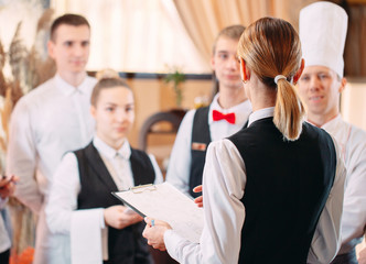 restaurant manager and his staff in kitchen. interacting to head chef in commercial kitchen.