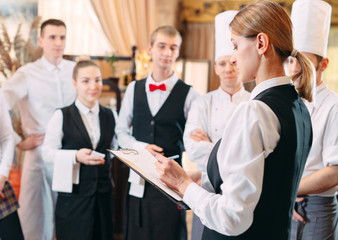restaurant manager and his staff in kitchen. interacting to head chef in commercial kitchen.