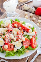 Caesar salad with salted salmon on a white plate, selective focus