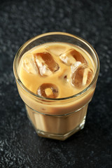 iced caramel coffee in a glass with cold milk. Summer drink