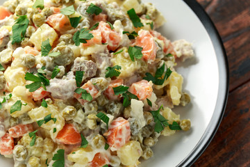 Russian traditional salad Olivier with vegetables and meat.