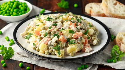 Russian traditional salad Olivier with vegetables and meat.