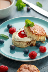 Classic scones with clotted cream, strawberries jam, english Tea and other fruit