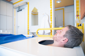 Man, a woman in her mid thirties enjoys a water / bath or physical therapy in an oxygen / carbonated bathtub