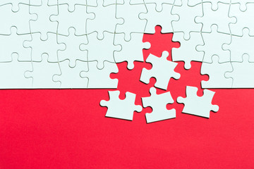 Red background made from white jigsaw puzzle pieces and place for your content - obrazy, fototapety, plakaty