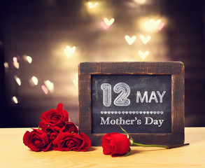 12 May Mothers day message on a small chalkboard with red roses
