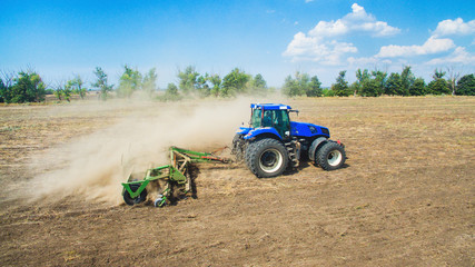 A tractor plowing and sowing in the field