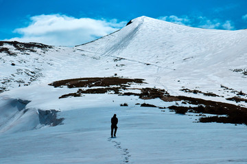 the tourist is dangerously out on the snow cape in the mountains
