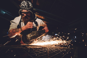 Worker Using Angle Grinder in Factory and throwing sparks
