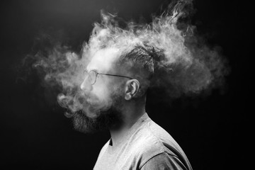 Concept. Smoke enveloped the head man. Portrait of a Bearded, stylish man with smoke. Secondhand...
