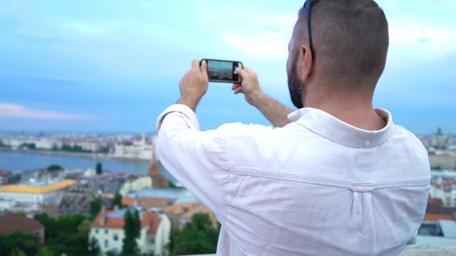 Young man taking photo of Budapest cityscape