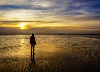 silhouette of woman at sunset by the sea in denmark