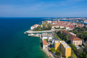 Aerial view of city of Zadar. Summer time in Dalmatia region of Croatia. Coastline and turquoise water and blue sky with clouds. Photo made by drone from above.
