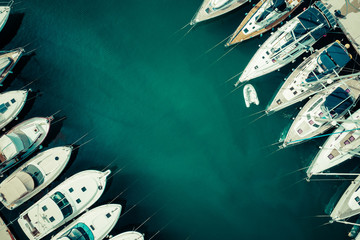 Luftaufnahme von vielen weißen Booten und Yachten, die im Jachthafen festgemacht sind. Foto von oben per Drohne gemacht.
