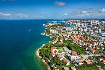 Aerial view of city of Zadar. Summer time in Dalmatia region of Croatia. Coastline and turquoise water and blue sky with clouds. Photo made by drone from above.