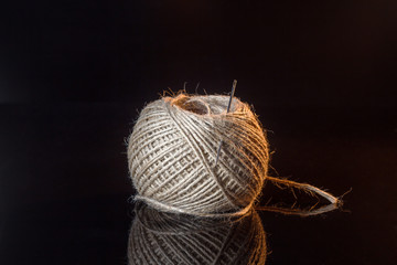 A ball of coarse thread with a needle
