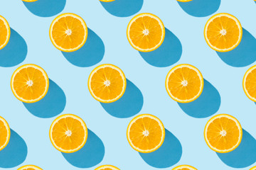 Cut half of orange on a blue background. Minimalism. Concept of tropics, healthy eating, vitamins. Flat lay, top view.