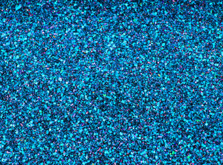 Background sequin. Blue background. Holiday abstract glitter background with blinking lights. Fabric sequins in bright colors. Fashion fabric glitter, sequins. Defocused. 