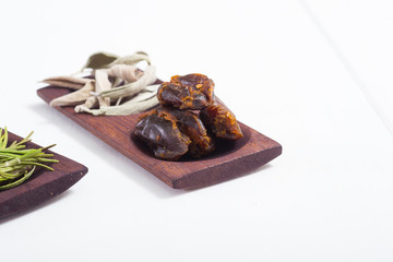 dried fruits and spices on wooden tray, white table