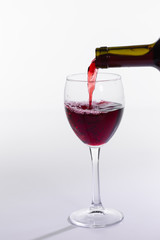Red wine bottle pour glass on white background