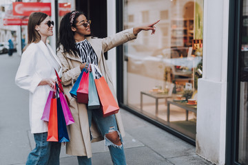 Two beautiful women enjoying shopping and choosing what to buy together