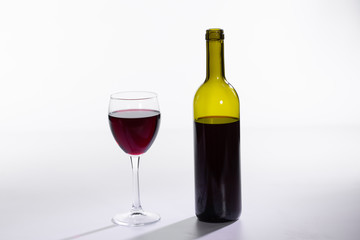 Glass and bottle with red wine on white background