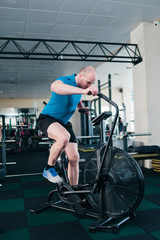 Powerful man trains with air bike. Functional training concept