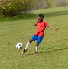 Hampshire, England, UK. April 2019. A nine year old footballer dribbles the soccer ball during a...