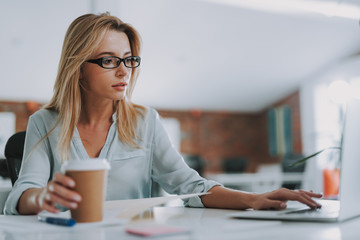 Thoughtful woman touching the keyboard of her laptop