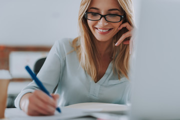 Close up of happy woman making notes and smiling