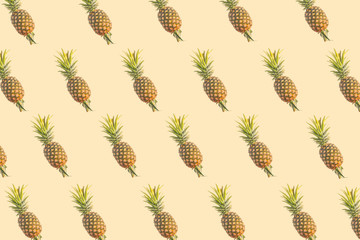 Pattern of fresh pineapples on beige background. From top view