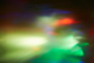 Multicolored blurred spots of light on a dark background.