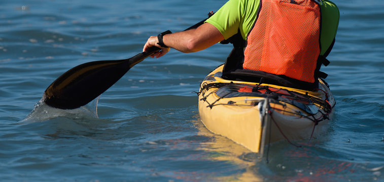 A Paddler Races His Ocean Kayak Surfski Towards The Finish 