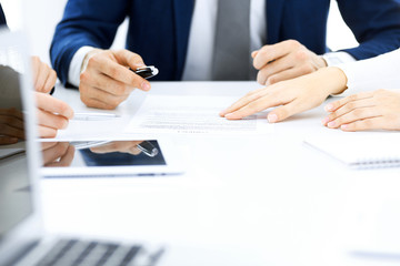Group of business people and lawyers discussing contract papers sitting at the table, close-up. Successful teamwork, cooperation and agreement concepts