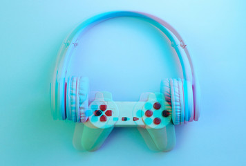 Gаmer concept. Gamepad with headphones. 80s. Retro wave, blue neon light, glitch effect. Top view. Glitch effect