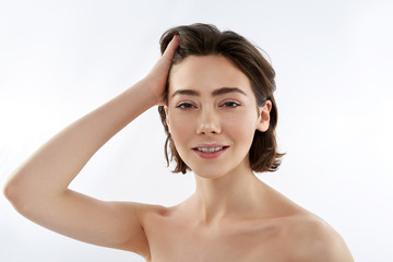 Naklejka premium Young smiling brunette female touching her hair