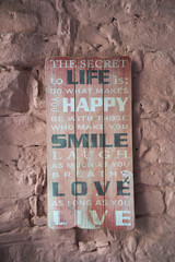 Tablica na starym murze z napisami szczęścia