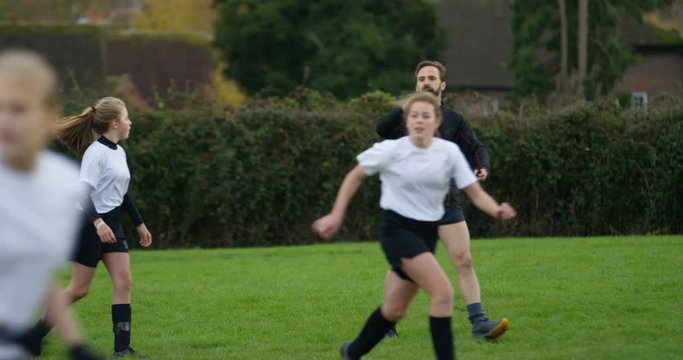 4K Soccer coach acting as referee at a girls' football match. Slow motion.