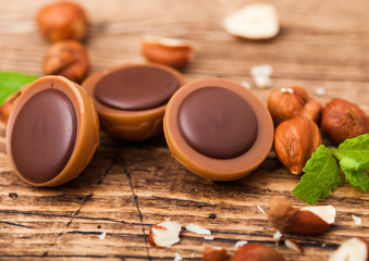 Box of homemade candies on wooden background with mint and nuts. A hazelnut in Caramel and...