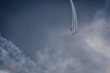 Three planes in the sky diving down into the clouds