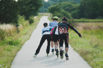 Four older people riding on roller skates in line