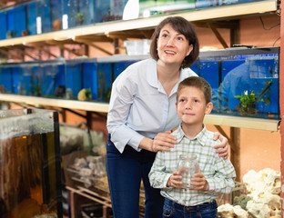 Boy with mother choosing aquarium fish