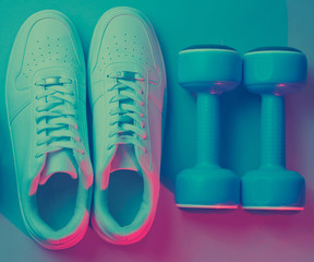Lifestyle concept. Dumbbells, headphones, sneakers. Retro wave, neon light, ultraviolet. Top view, minimalism