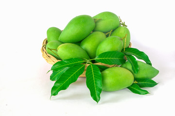 green mangos in a basket on a white background