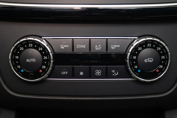 Rear central console on the panel inside the car close-up with climate control and seat heater buttons in gray and black. Auto service industry. Comfort concept.
