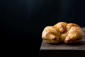 Close Up of Fresh Baked Croissant on wood table with Coffee Mug and  news paper on Relaxing Morning at Home, Bread and coffee, breakfast Healthy food of the city life