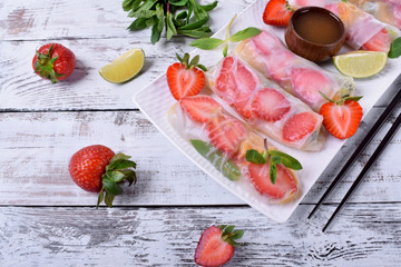 Spring rolls with strawberry, fruits and sauce. Vietnamese cuisine snack