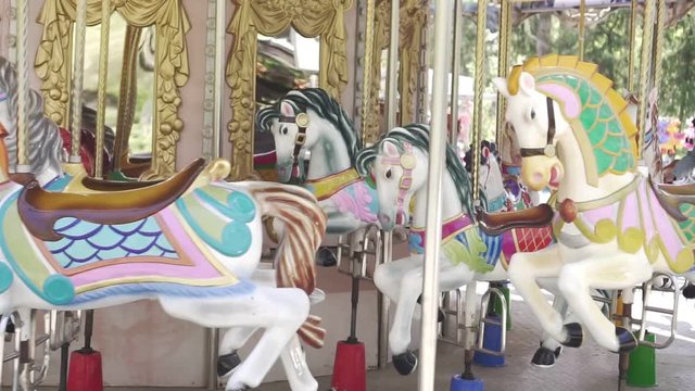 Family rides on the carousel on horseback, amusement Park.