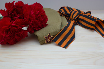Victory day composition with clove, flight cap and saint George ribbon with free space