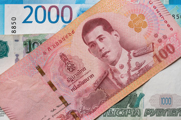 Russian rubles and Thai baht close-up. Ruble-butt rate.